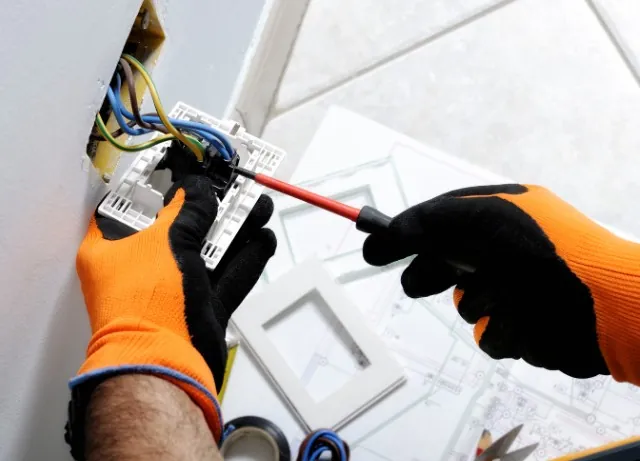 Electricista cambiando un interruptor con destornillador aislado en Torremolinos (Málaga)