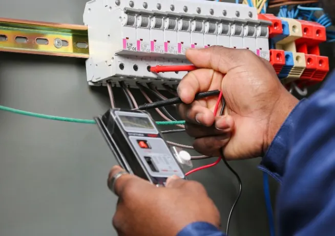 Señales de que tu cuadro eléctrico está anticuado Medición de tensión en las bornas del cuadro eléctrico con multímetro digital