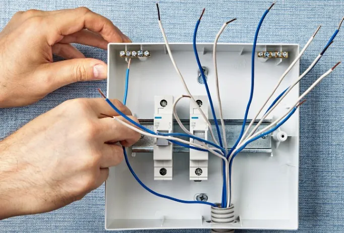 Electricista montando magnetotérmicos en un cuadro eléctrico nuevo