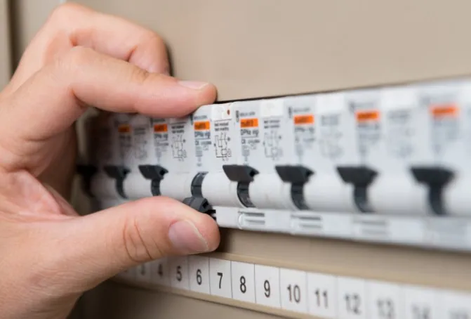 Por qué salta el diferencial y cómo solucionarlo Mano rearmando un magnetotérmico en el cuadro eléctrico de una vivienda